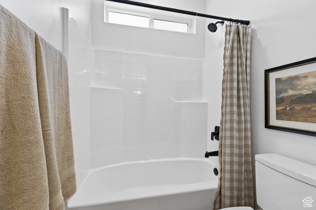 Bathroom featuring shower / bath combo with shower curtain and toilet