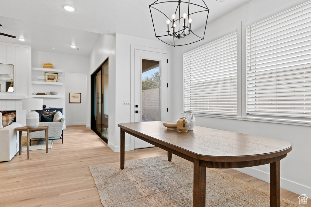 Dining space featuring light wood-type flooring, baseboards, recessed lighting, and a chandelier