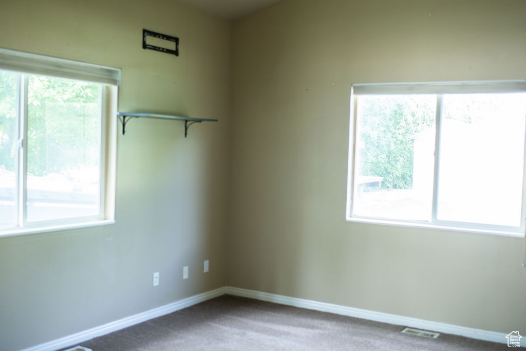 Empty room featuring carpet and baseboards