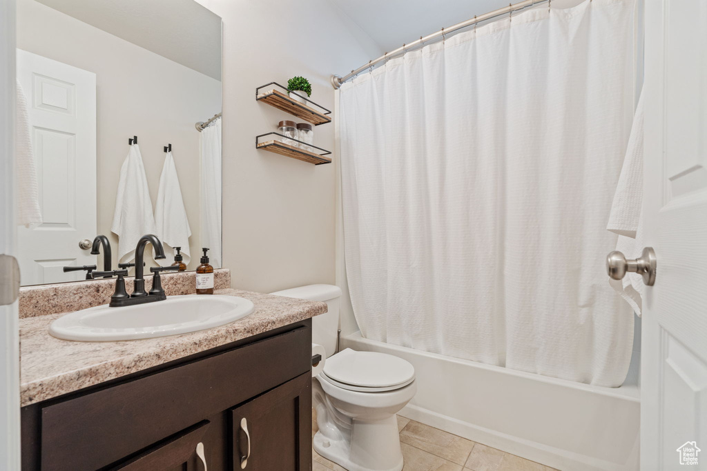 Full bathroom featuring vanity, toilet, shower / tub combo, and tile patterned floors