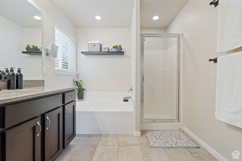 Bathroom featuring vanity, a garden tub, a shower stall, tile patterned floors, and recessed lighting