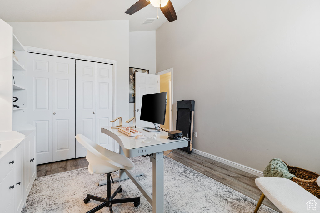 Office space with wood finished floors, vaulted ceiling, ceiling fan, and baseboards