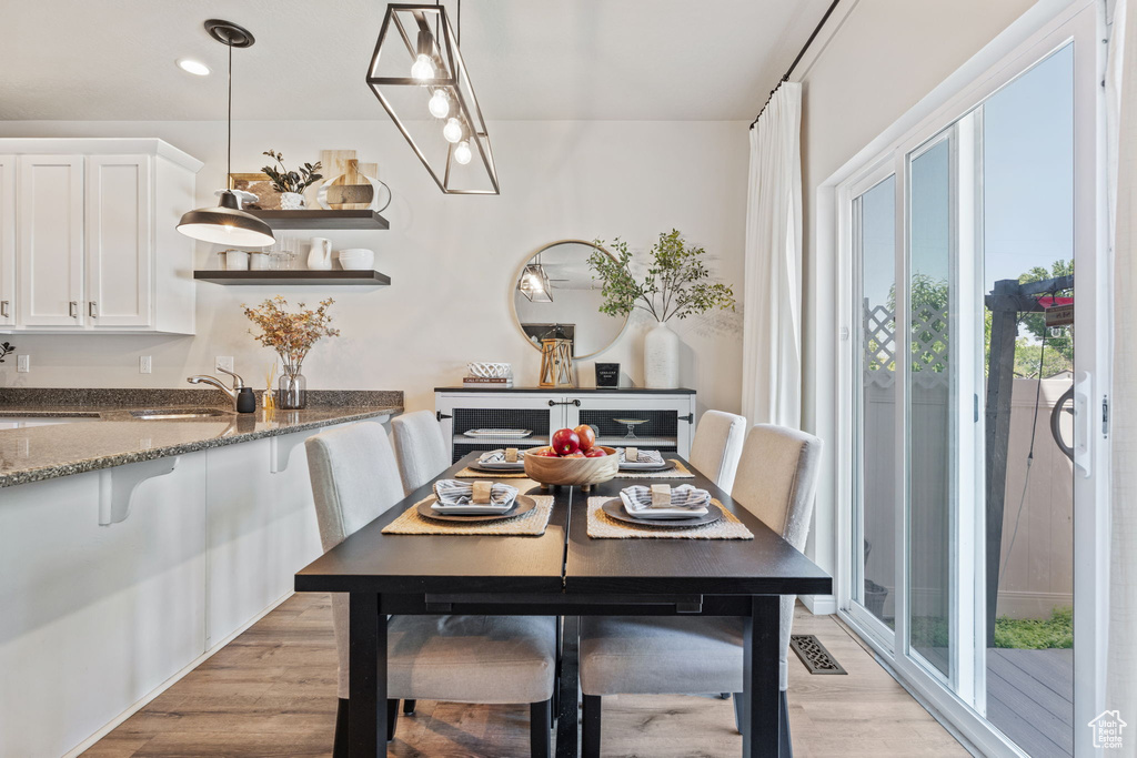 Dining space with light wood-type flooring and recessed lighting
