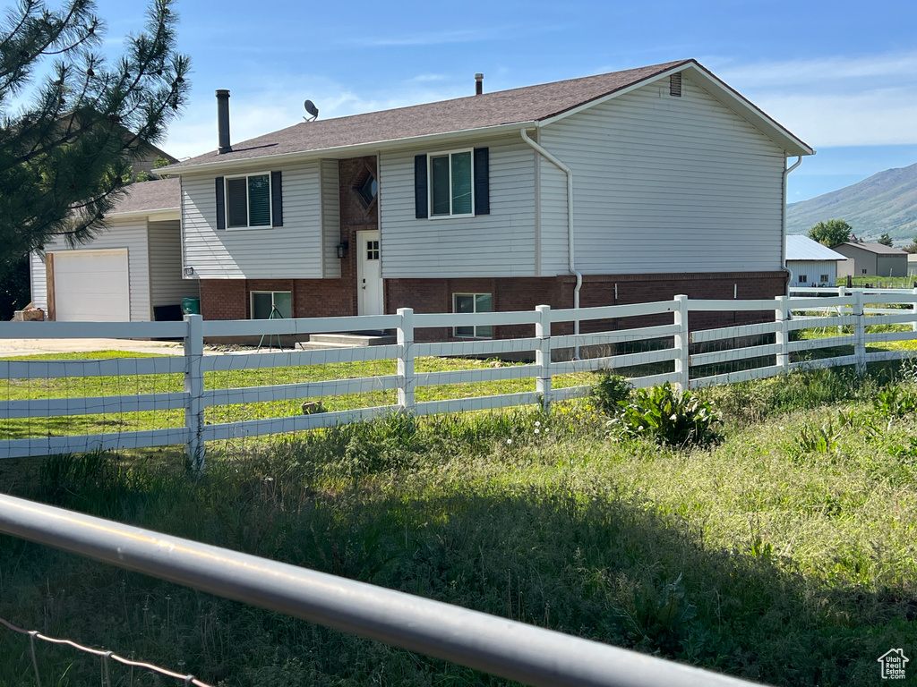 Raised ranch with an attached garage, a mountain view, and brick siding