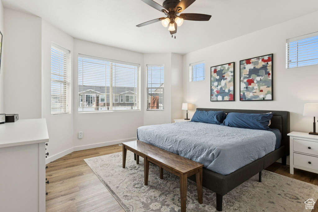 Bedroom with multiple windows, light wood-style flooring, and baseboards