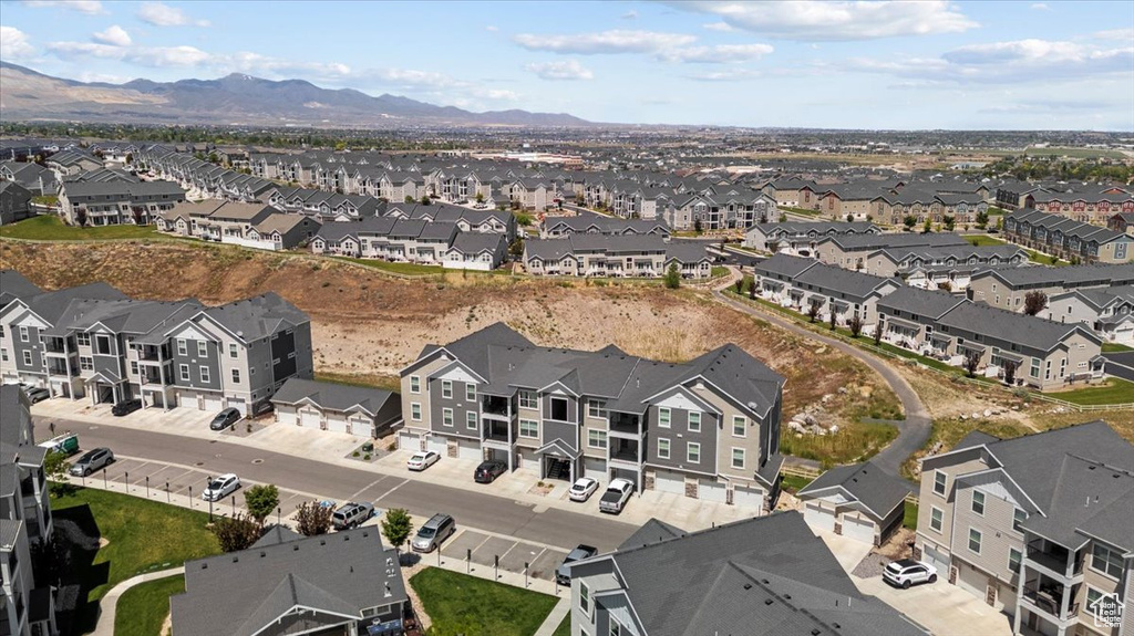 Aerial view of property and surrounding area with nearby suburban area and a mountain backdrop