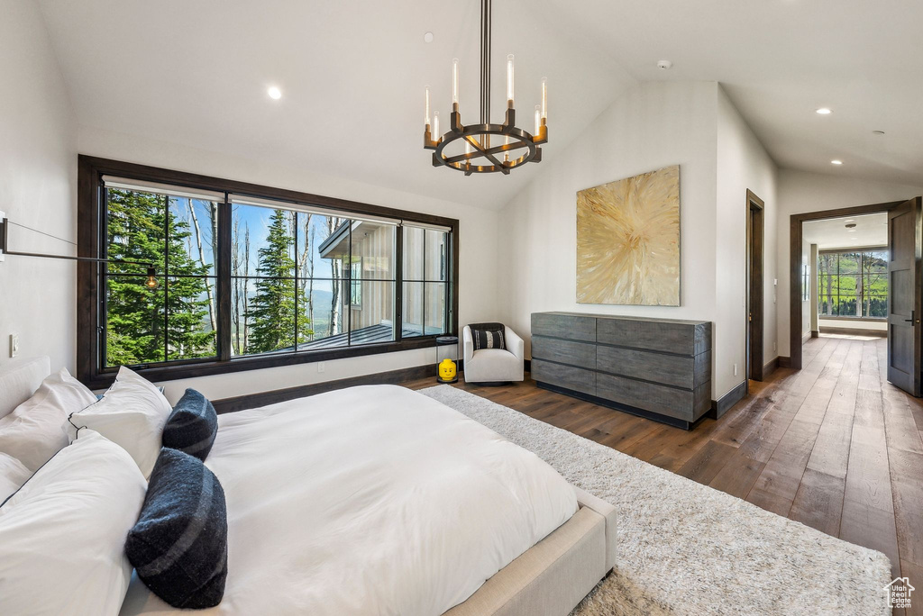 Bedroom featuring vaulted ceiling, dark wood-type flooring, a chandelier, recessed lighting, and baseboards
