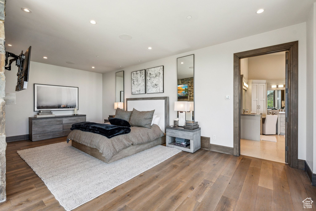 Bedroom with wood finished floors, baseboards, and recessed lighting