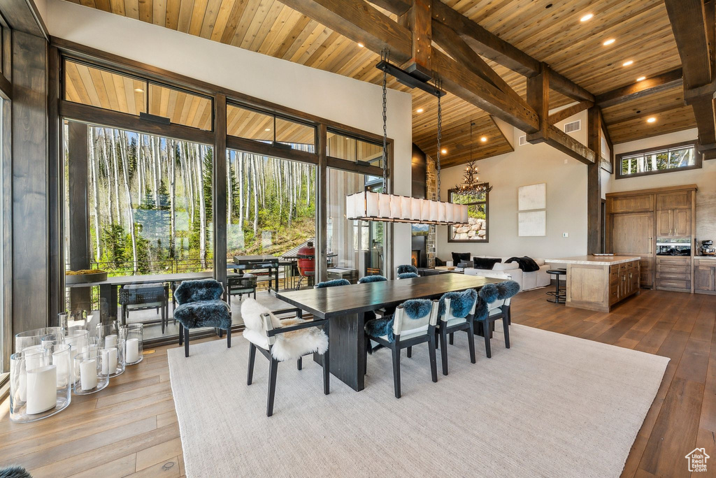 Dining area with wood ceiling with exposed beams, dark wood finished floors, high vaulted ceiling, and recessed lighting