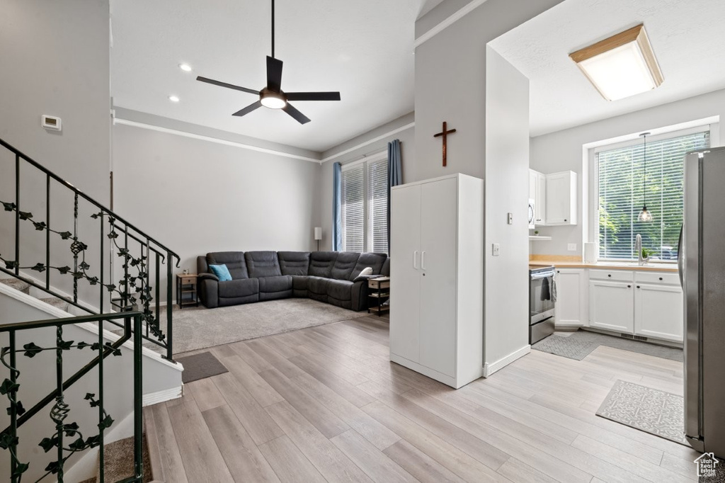 Living area with healthy amount of natural light, light wood finished floors, and recessed lighting