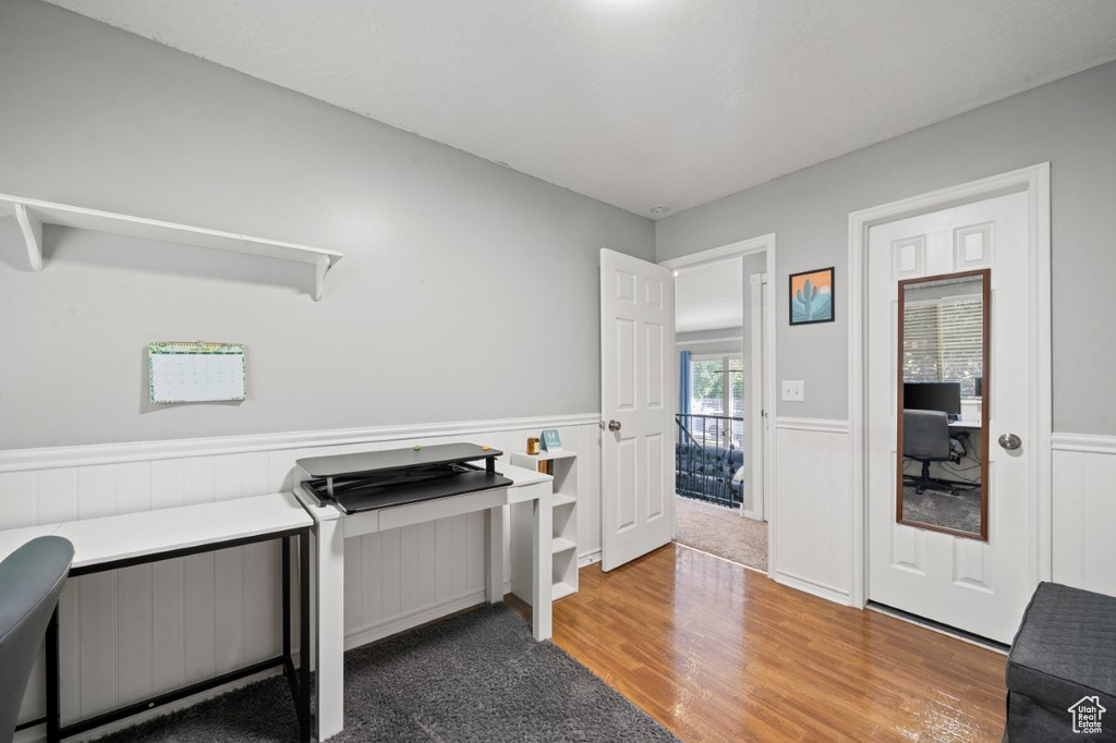 Office space with a wainscoted wall and wood finished floors
