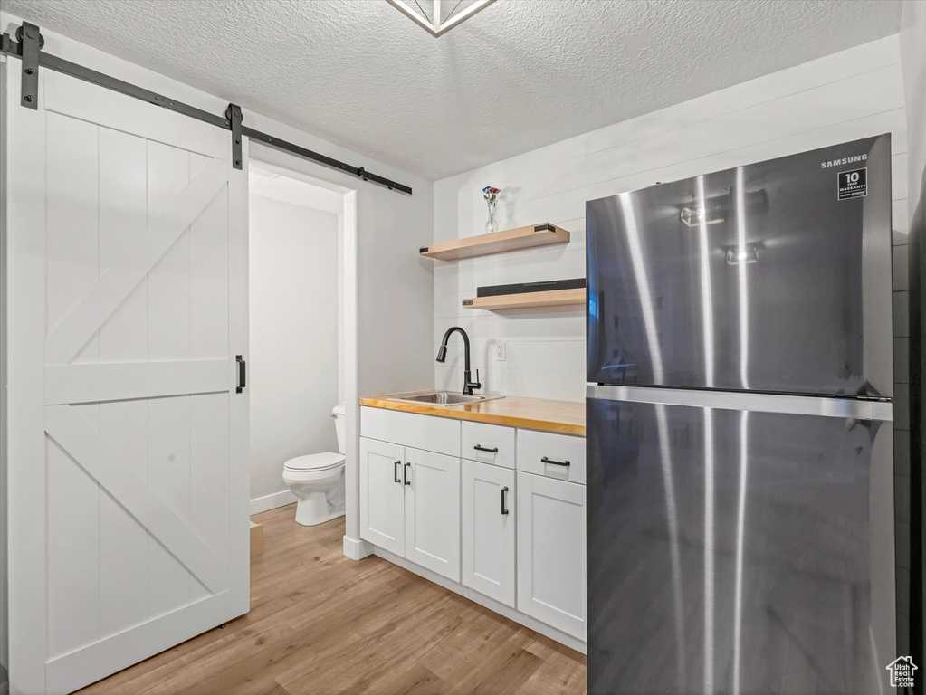 Bathroom featuring wood finished floors, a textured ceiling, toilet, and vanity