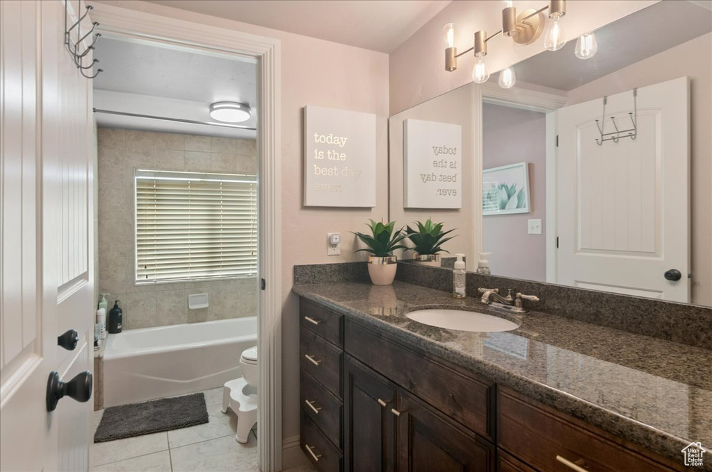 Full bath with toilet, vanity, tile patterned flooring, and shower / tub combination