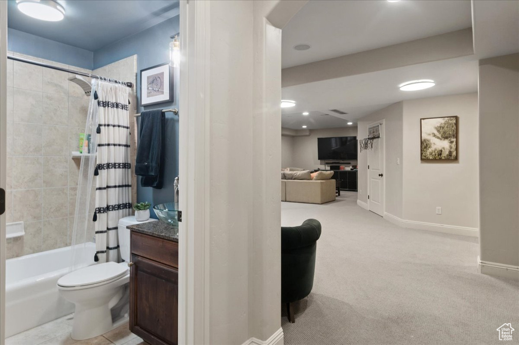 Bathroom featuring shower / tub combo, toilet, vanity, baseboards, and recessed lighting