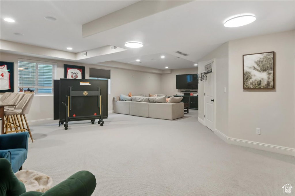Living area with carpet flooring, baseboards, and recessed lighting