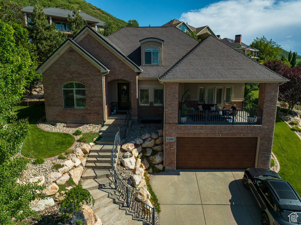 View of front facade featuring brick siding, concrete driveway, and a garage