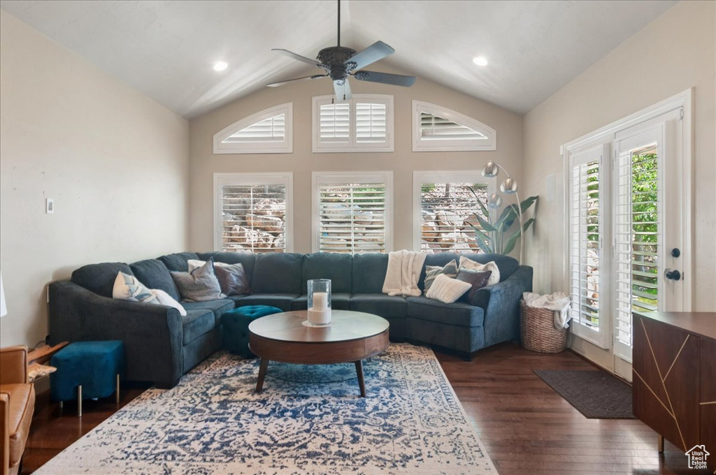 Living room with dark wood-style flooring, vaulted ceiling, and a ceiling fan