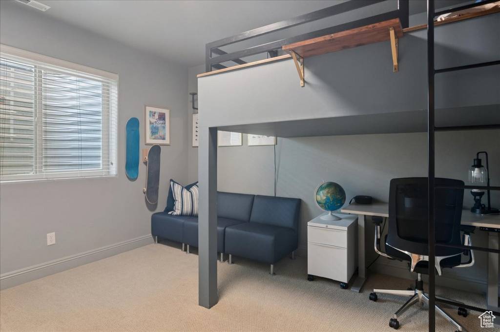 Bedroom with light carpet, a desk, and baseboards