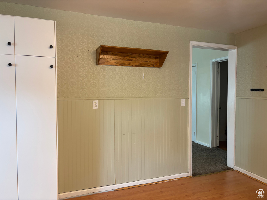 Unfurnished room with wainscoting, wood finished floors, and wallpapered walls