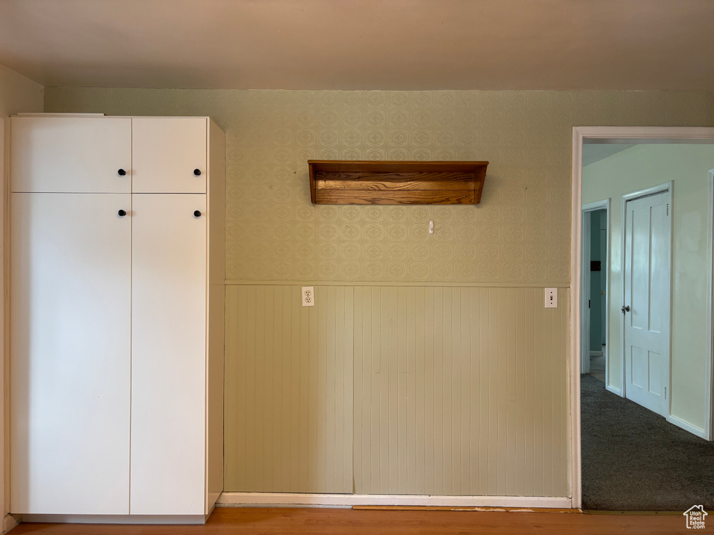 Unfurnished bedroom featuring wainscoting and wallpapered walls