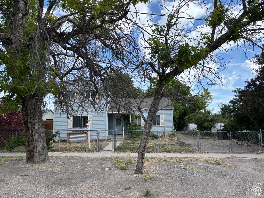 View of front of property featuring a gate, a fenced front yard, and a porch