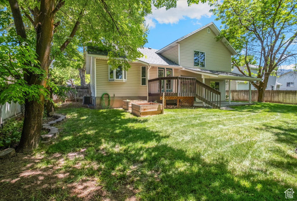 Back of house with a deck, a garden, and cooling unit