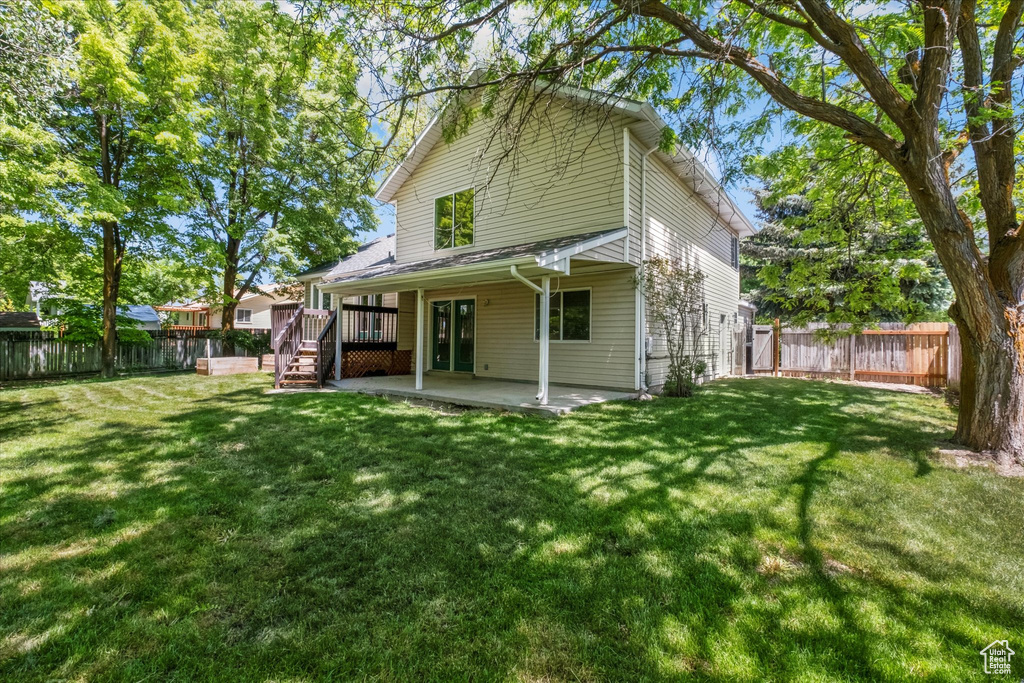Rear view of property featuring a patio, a wooden deck, and stairway
