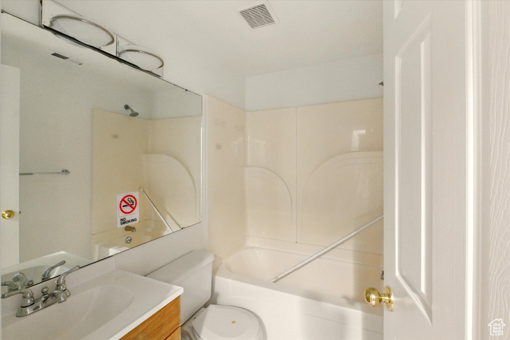 Bathroom featuring vanity, shower / washtub combination, and toilet