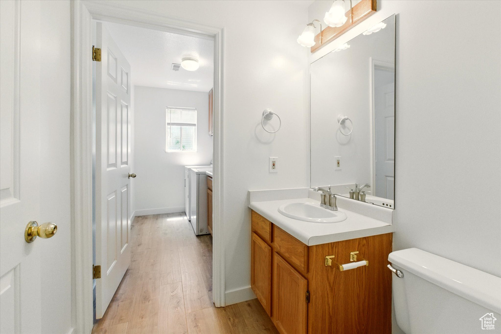 Bathroom featuring vanity, wood finished floors, and toilet