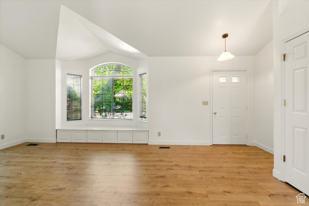 Entryway featuring vaulted ceiling, light wood-type flooring, and baseboards