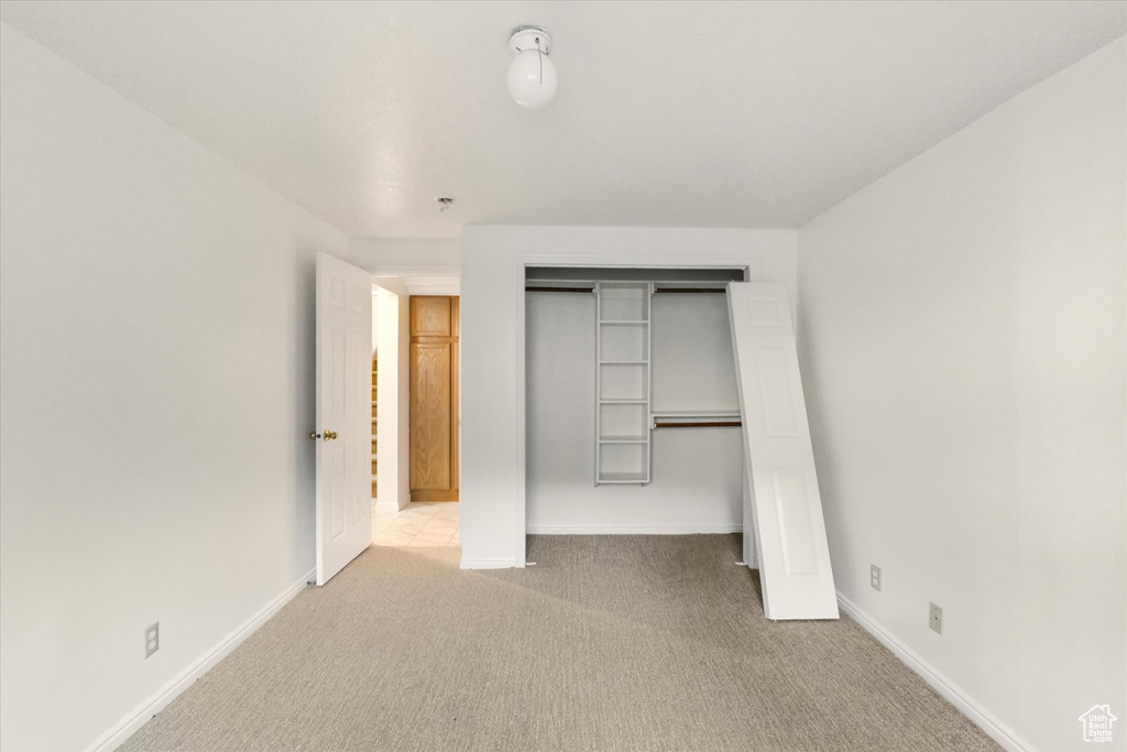 Unfurnished bedroom featuring carpet flooring, a closet, and baseboards