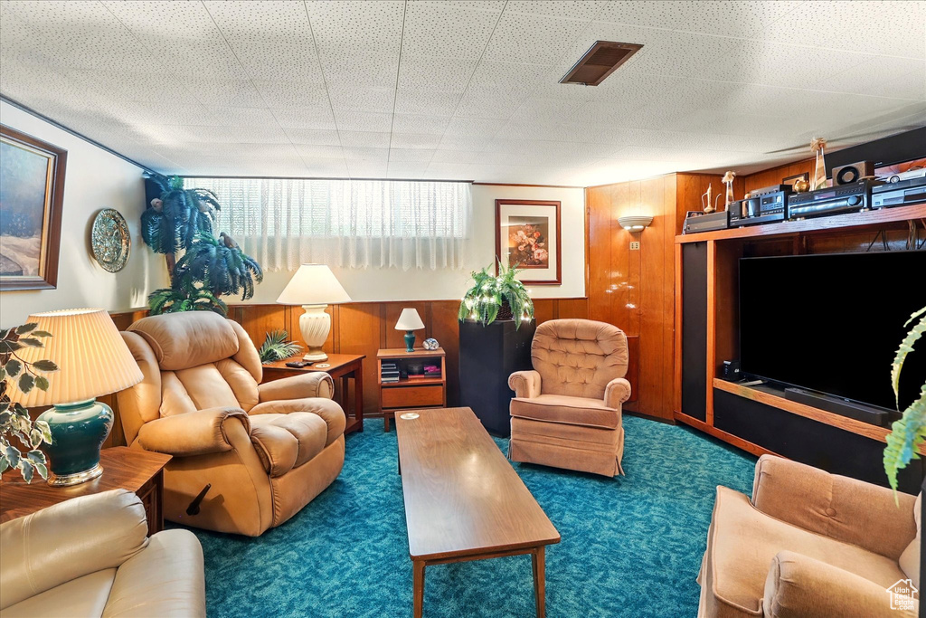 Living area with carpet flooring and wooden walls