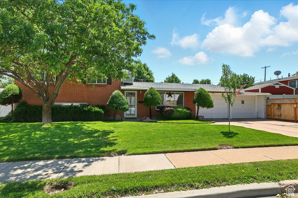 Split level home featuring brick siding, an attached garage, and concrete driveway