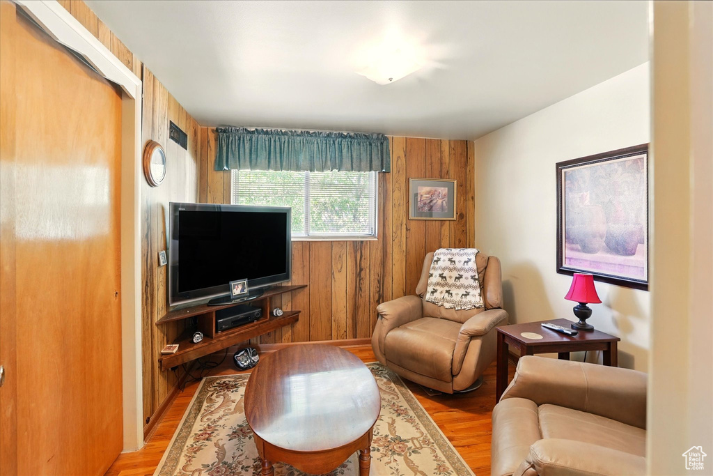 Living area featuring light wood finished floors and wood walls