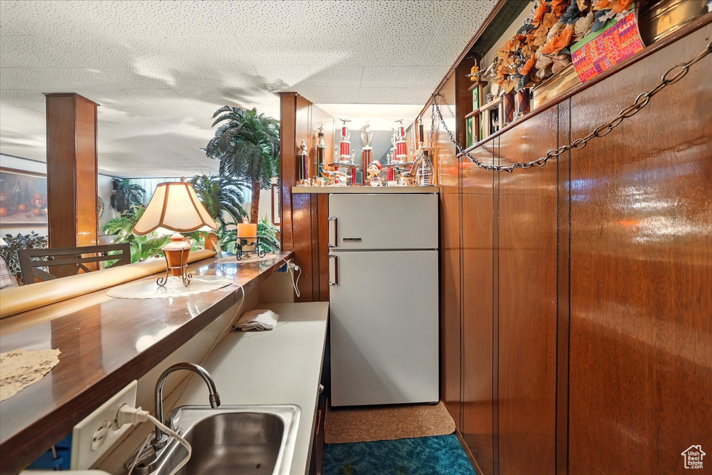 Bar area featuring freestanding refrigerator and a sink