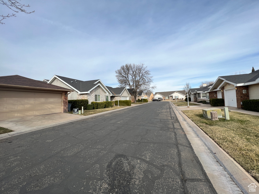 View of asphalt street with a residential view and curbs