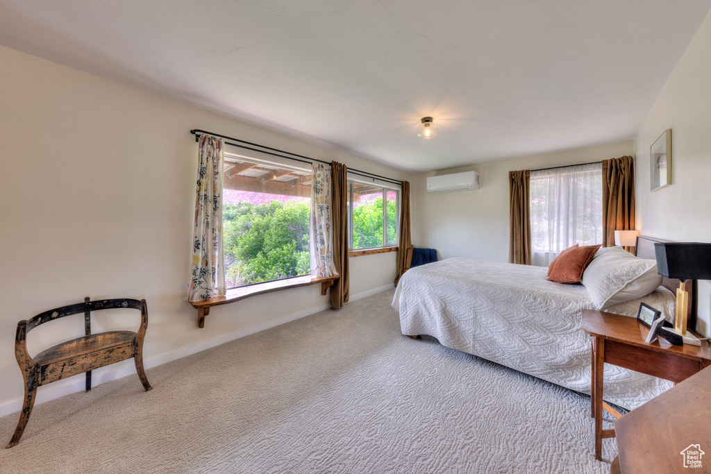Bedroom featuring an AC wall unit, carpet floors, and baseboards