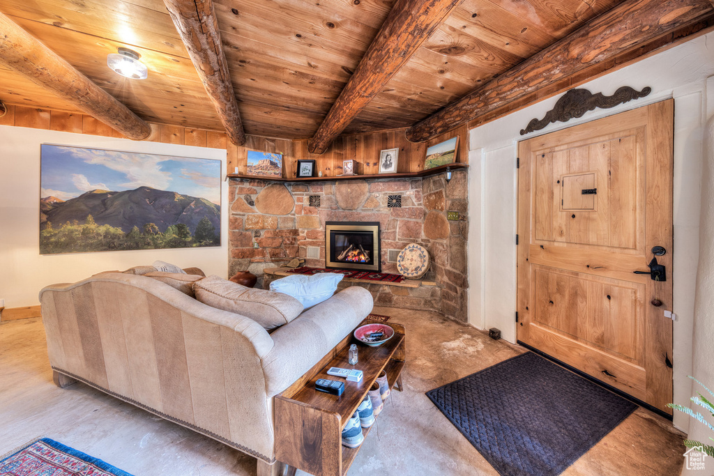 Living room with wooden ceiling with exposed beams, a fireplace, and baseboards