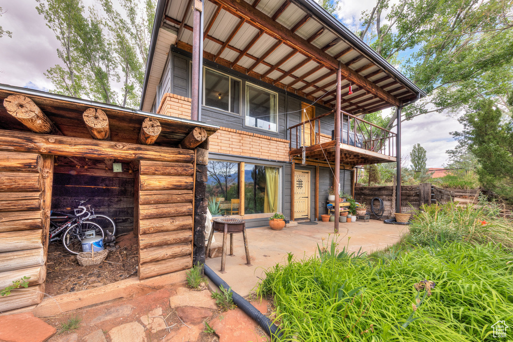 Rear view of house with a patio area and a balcony