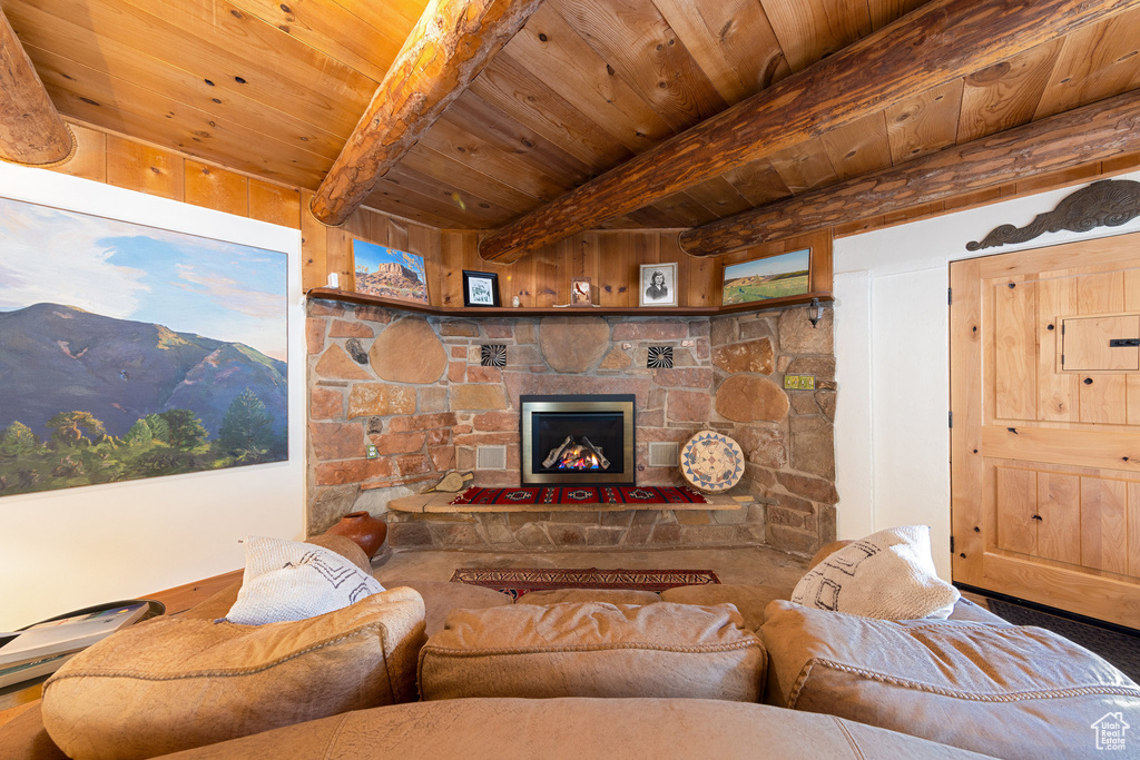 Living room featuring wooden ceiling with exposed beams and a fireplace
