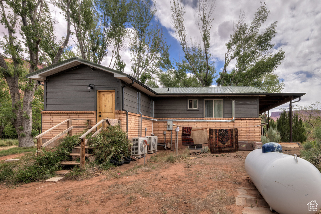 View of front of house featuring brick siding and ac unit