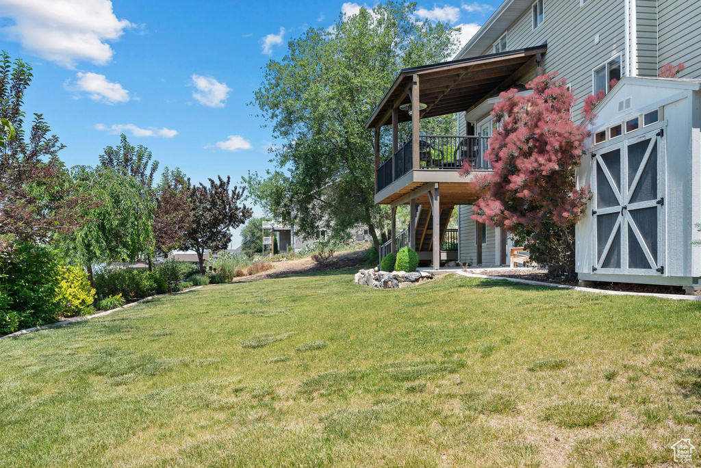 View of green lawn featuring stairway and a deck