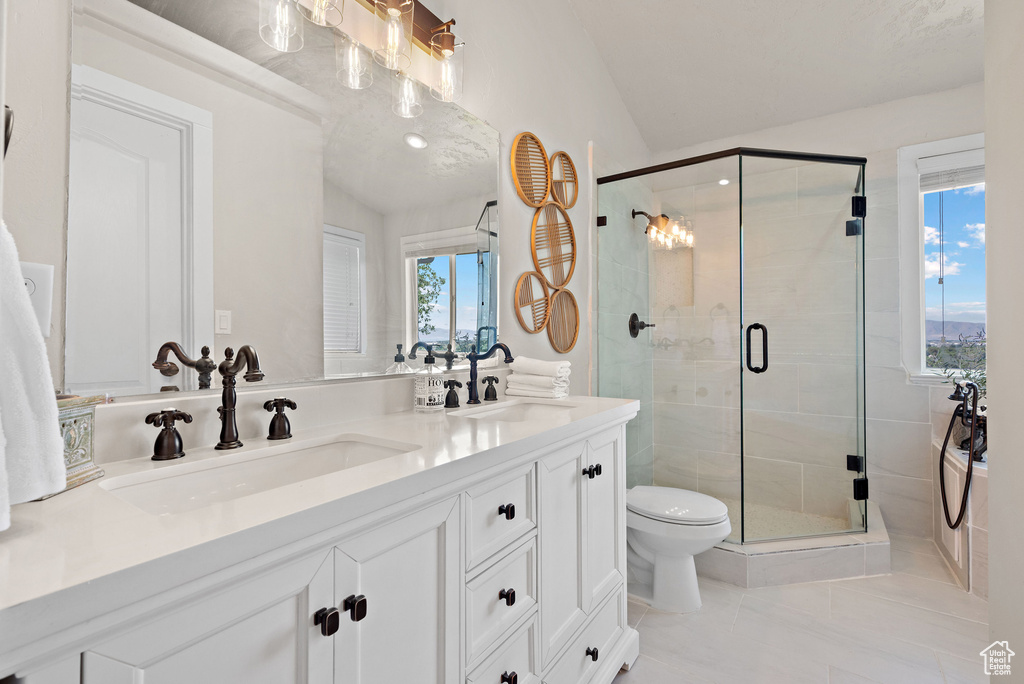 Full bathroom with double vanity, a stall shower, toilet, tile patterned flooring, and vaulted ceiling