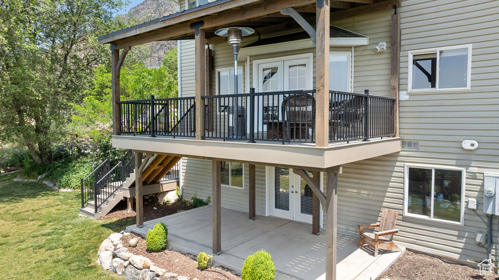 Rear view of property featuring french doors, a yard, a patio area, and stairway