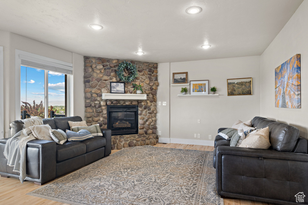 Living area featuring wood finished floors, a fireplace, recessed lighting, and baseboards