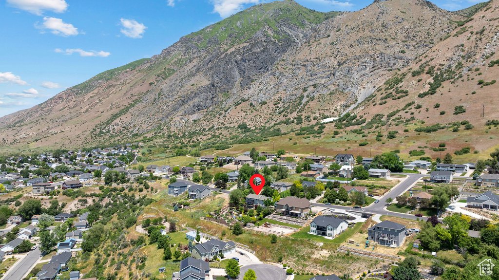 Aerial view of property and surrounding area with mountains and nearby suburban area