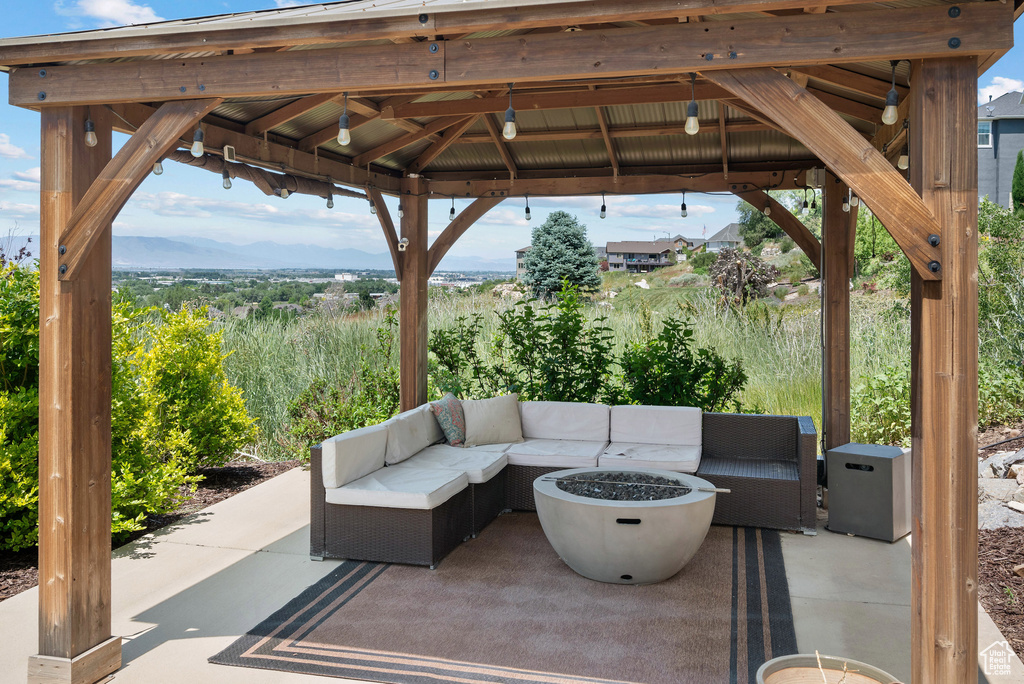 View of patio with a gazebo and an outdoor living space with a fire pit