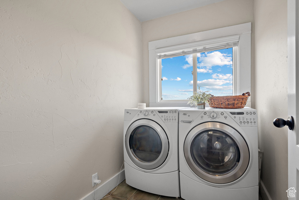 Washroom featuring washer and clothes dryer, healthy amount of natural light, and baseboards