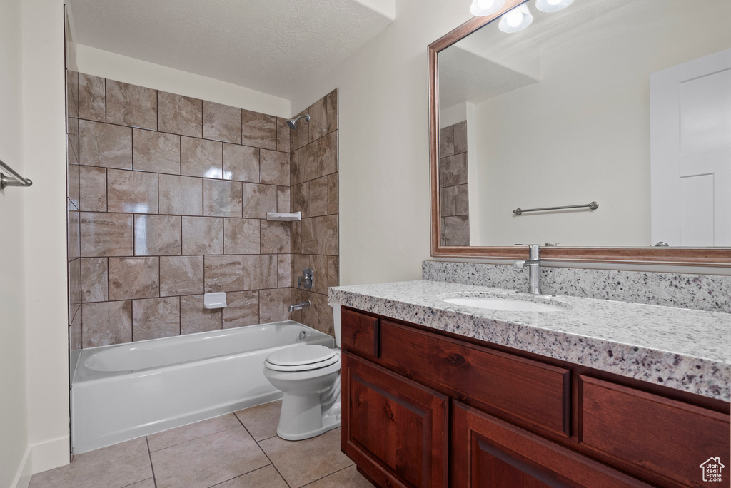 Full bathroom with vanity, tile patterned floors, toilet, and  shower combination