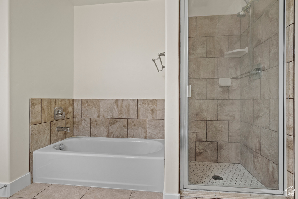 Bathroom featuring tile patterned flooring, a garden tub, and a shower stall